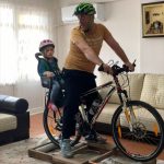 baba ve kızı bisiklet düzeneğini kullanırken görülüyor